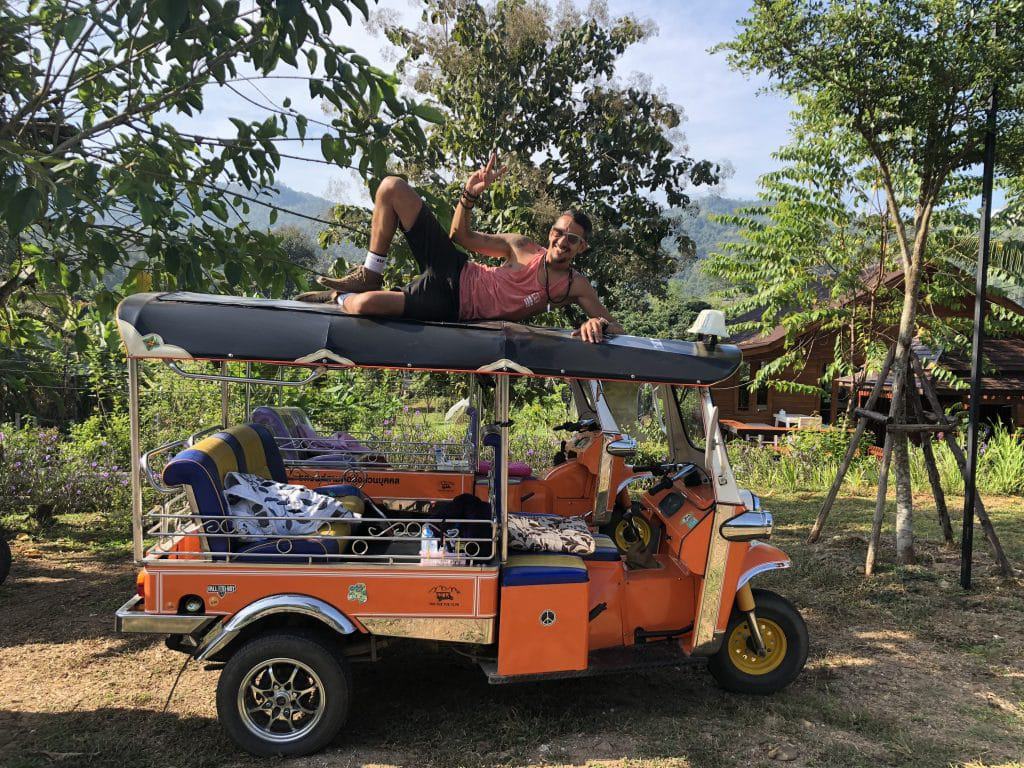 5 Reasons to book a Tuk Tuk Club Adventure in 2022 2 A young man relaxing on the roof of a Tuk Tuk