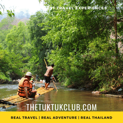 An adventurous traveller sitting on a bamboo raft floating through the forest of Northern Thailand