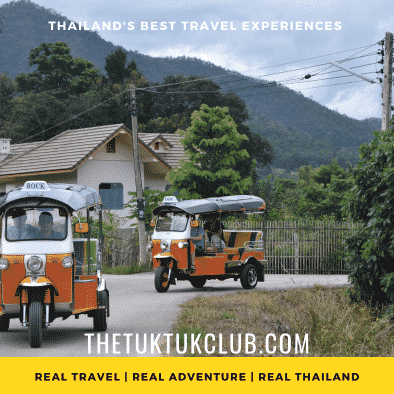 Two Tuk Tuks going round a corner through a small village in the mountains of Northern Thailand