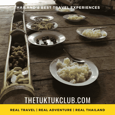 Traditional rural Thai food laid out in large bamboo containers with plates of rice ready for a delicious meal