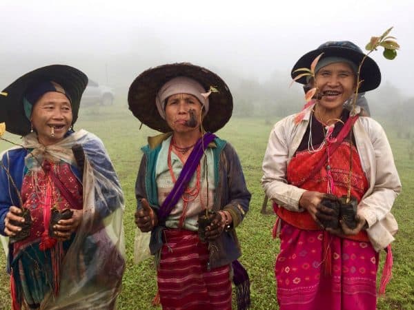 Three Karen Hill Tribe women smiling and smoking after a day working in the fields