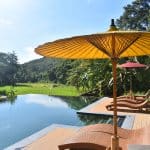 An infinity pool with sun loungers and umbrellas