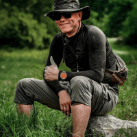 A Thai man sitting in the countryside smiling