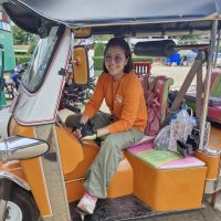 A Thai woman sitting in a Tuk Tuk