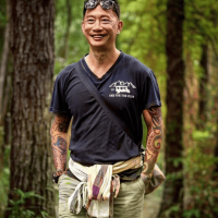 A Thai man standing in a forest