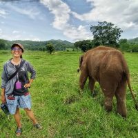A woman standing next to an elephant
